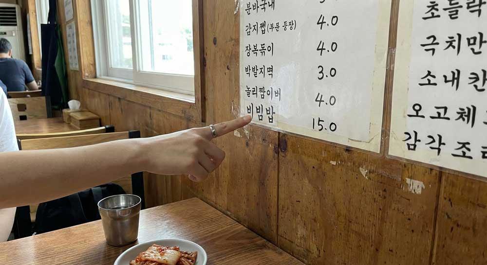 Pointing at “bibimbap” on a Korean restaurant menu