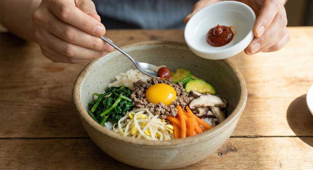 Adding gochujang little by little with a small spoon